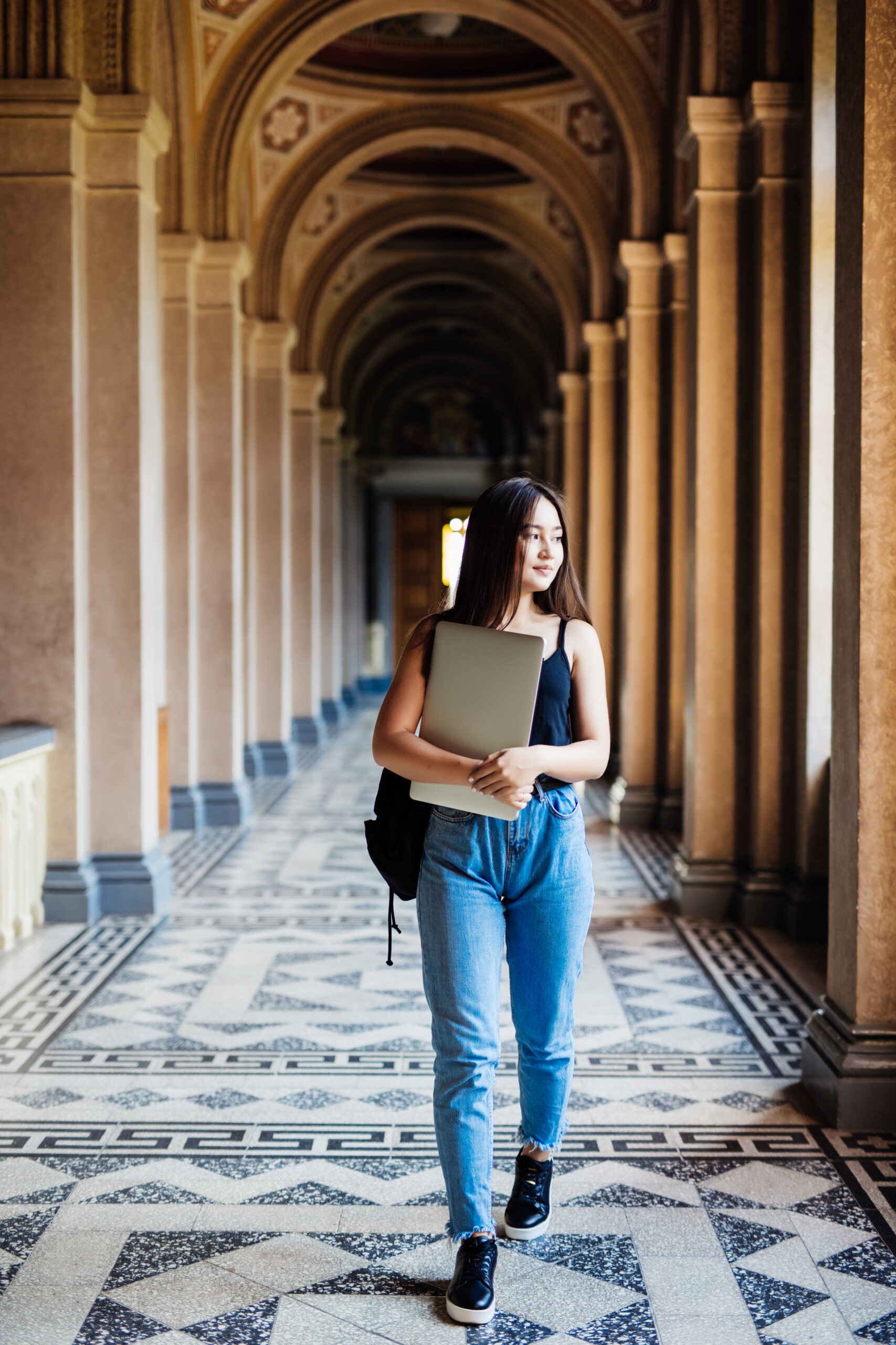Portrait of young Asian woman student using a laptop or tablet in smart and happy pose at university or college